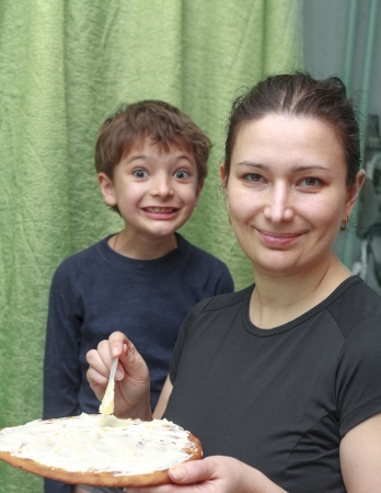 Smiling mother and son having fun in the kitchen with pieの写真素材