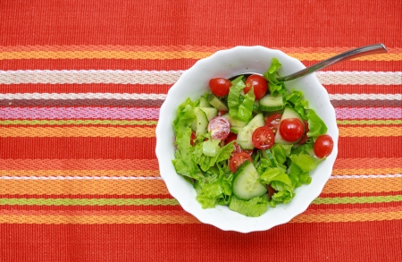 A green salad in a stylish white bowl  With rocket leaves cherry tomatoes spanish onions and capsicum の写真素材
