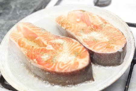 Preparing healthy salmon lunch in a frying panの写真素材
