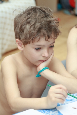 Cute little boy painting with brushの写真素材