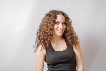 curly hair brunette on white background weared black shirt positive girl joy happyness conceptの写真素材
