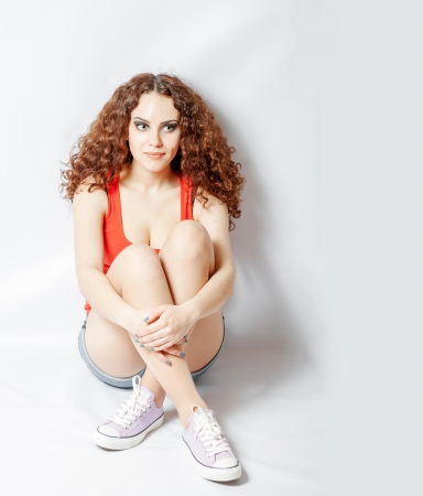 a Young woman sitting cross legged in sport wear front viewの写真素材