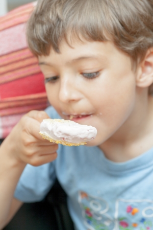 Cute little boy eating chocolate ice cream indoorsの写真素材