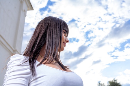 beautiful long hair brunette woman against skyの写真素材