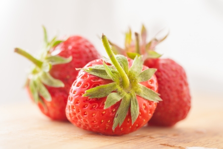 three strawberries on wooden tableの写真素材