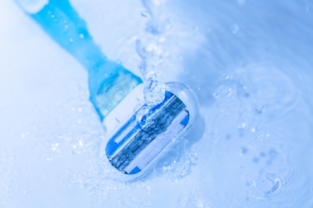 razor close-up with water splash on blue  razor to shave in a spray of water dropletsの写真素材