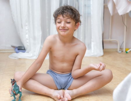 little boy does exercises on yoga  Boy sitting on floor meditating  Yoga  Lotus Position の写真素材