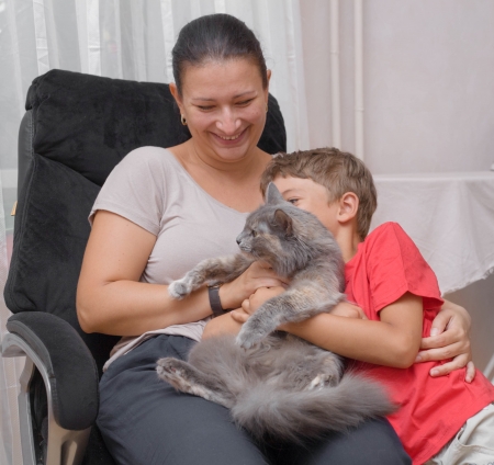 mother and son with cat in the living room having funの写真素材