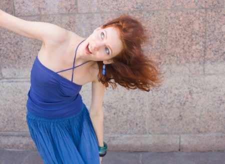 redhead 20s women in blue tank top and skirt dancing salsa outdoor in loneliness, summertime, dayの写真素材