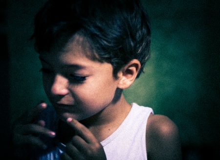 grainy film shot imitation - boy indoors closeup, focused light on the one sideの写真素材