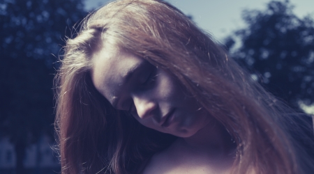 Women in sorrow. 20s female outside close-up image. Portrait of a beautiful young 20s women in the park in evening.の写真素材