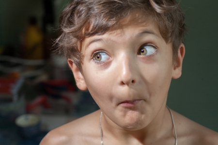 surprised 7 years old boy make funny facesの写真素材