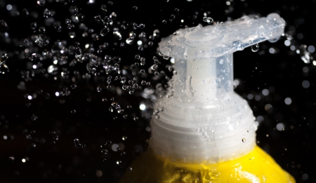 cosmetics tube head and water drops on the black background. Spa concept