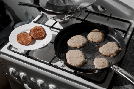 Pans with pancakes  on the stove in a kitchen の写真素材