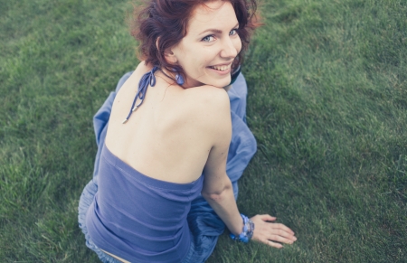 redhead smiling on grass, vintage looking photo shotの写真素材