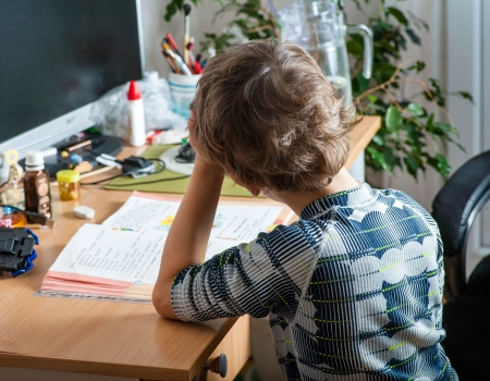 Little boy sitting rely on hand  Back view of schoolchildren studying at homeの写真素材