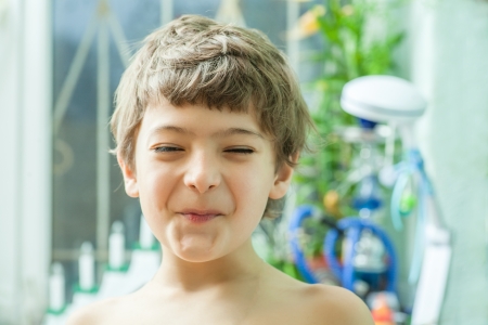 7 years old boy making faces indoorsの写真素材