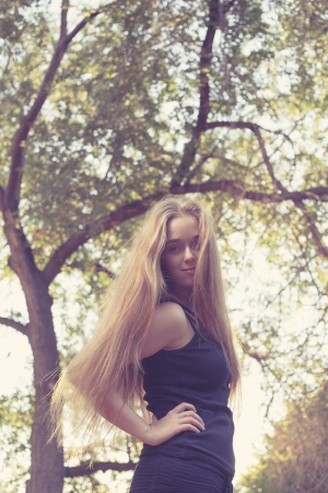 long haired blond women out doors, posing with hand on her waistの写真素材