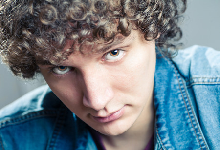Very closeup portrait of a young caucasian guy with curly hairの写真素材