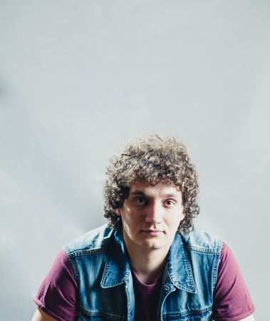 Curly white man in studio and a lot of copyspace
