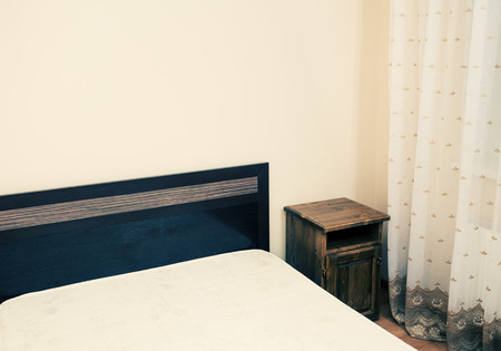 Colorized image of a part of a room with bed in a corner