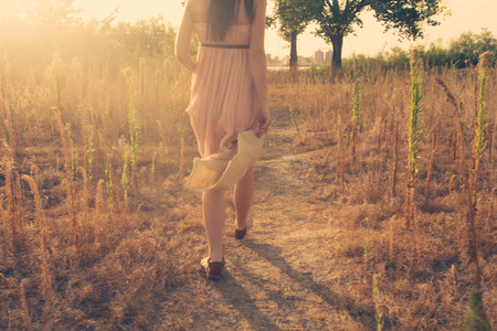Back view of women walking outdoors in summer timeの写真素材