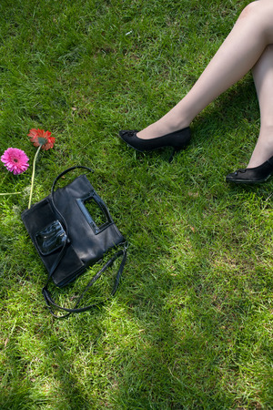 Legs of a women resting on green grass a lot of copyspaceの写真素材