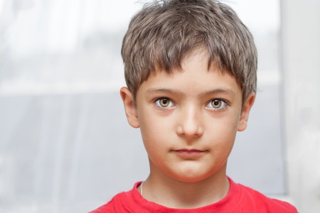 Boy in red shirt indoors closeup front view