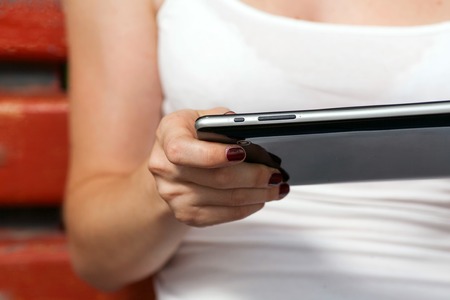 Student using her tablet pc on college campus very closeup image 