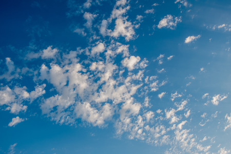Blue day sky with small clouds around.