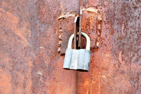 Closeup of the door lock on rusty metal stained gates.の写真素材