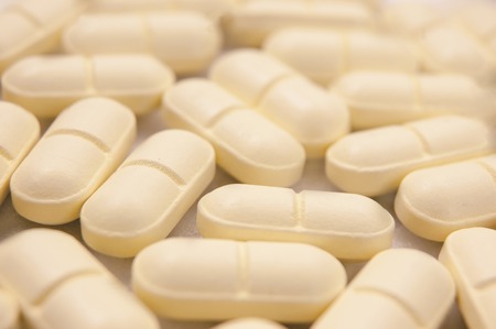 Spilled pills toned in brown background.の写真素材