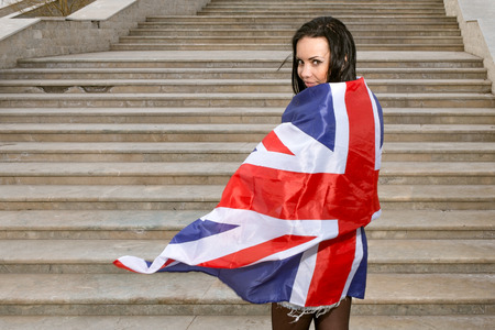 Young women with Union Jack flag against stairs.の写真素材