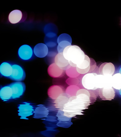 Defocused abstract street lights over water with reflection. Vanilla colors,  a lot of copyspace.