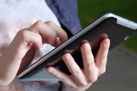 Tablet computer in female student arms closeup