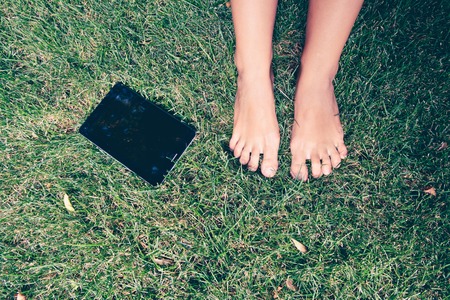 Women barefoot her tablet computer is lying near her Copyspaceの写真素材