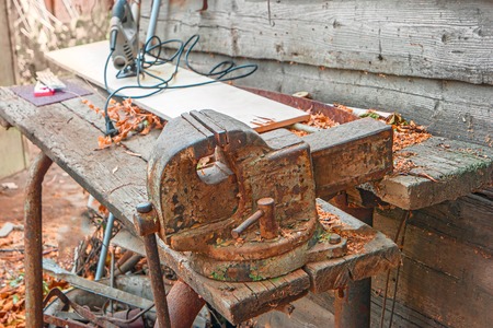 Weathered workbench with rusty metal clumpink device on.の写真素材