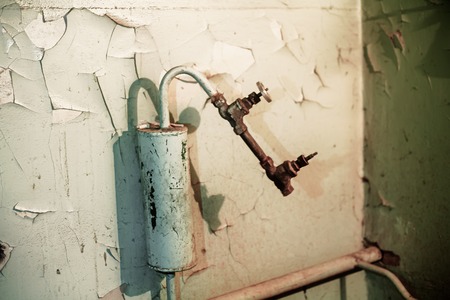 Old expansion tank and rusty hot water pipe