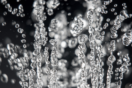 Drops of water levitation on black background, macro image. Frozen water movement.の写真素材
