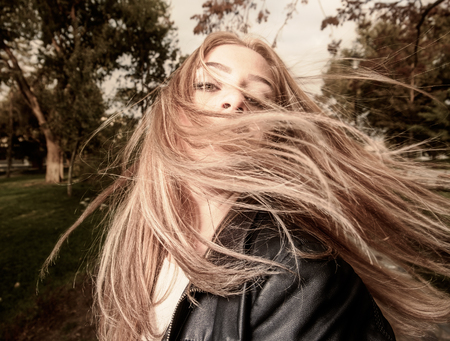 Young woman with hair swept by wind sepia toned image