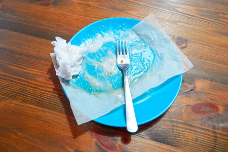 Empty dirty plate on wooden table left after lunch, from above viewの写真素材