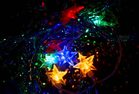 Defocused Xmass Garland with stars. Holiday Glowing Background. Shallow DOF. Toned image. Colorized shot.の写真素材