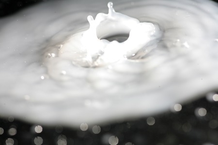 Milk splash on dark background with bokehの写真素材