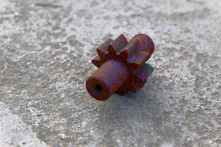 Old rusy gear on concrete floor of the plant, diagonal viewの写真素材