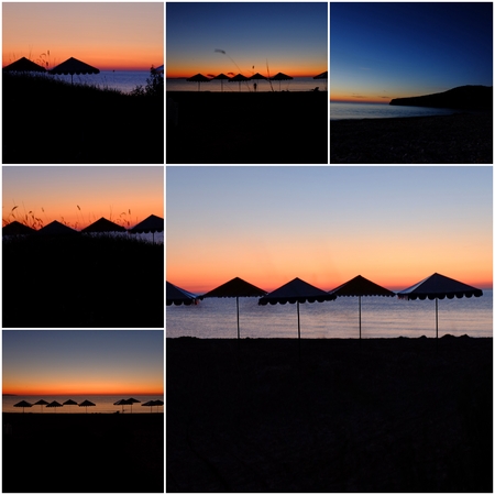 sea beach with umbrellas in front of orange sunset sky.の写真素材