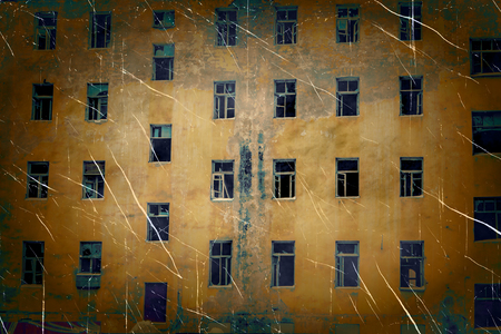 Abandoned building wall with broken glass windows retro photo imitation with hard vignette.の写真素材