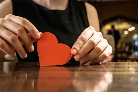Female hands holding red paper heart and copyspace.の写真素材