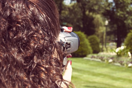 Girl taking photo with digital mirror camera closeup shot colorized toned image.