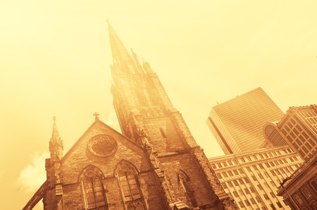 Old church in front of modern glass-and-steek buildings of Boston Downtown vintage look colorized with flareの写真素材