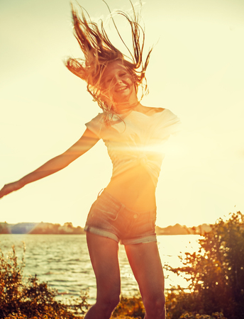 Happy girl dancing on the sunset beach retro colorの写真素材